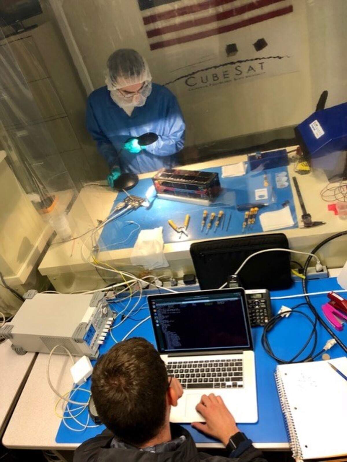 Mechanical engineering graduate student Aaron Fielden works with an unidentified student outside the Cal Poly clean room during testing of the ExoCube 2 satellite, a collaboration between the university and NASA’s Goddard Space Flight Center. Fielden was a project manager in 2016-17 for the ExoCube 2 satellite.