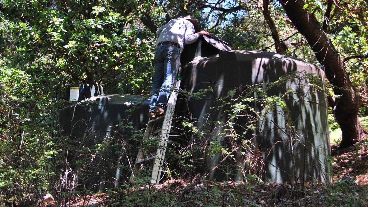 The Cambrian’s Mountain Musings columnist’s husband checks their backcountry home’s water tanks.