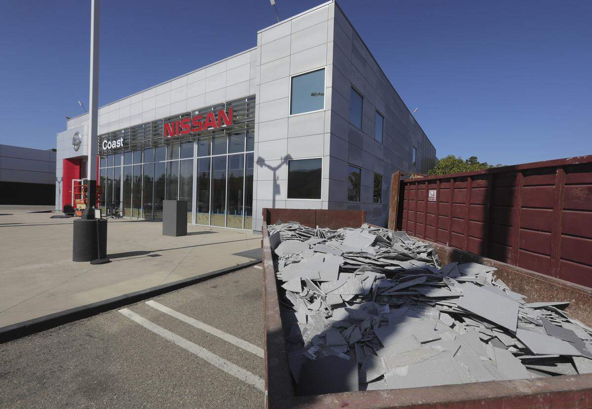 Coast Nissan closed in San Luis Obispo in early April. Workers were busy removing tile from the showroom on April 6, 2026, as the Porsche dealership next door takes over the space for luxury car sales.