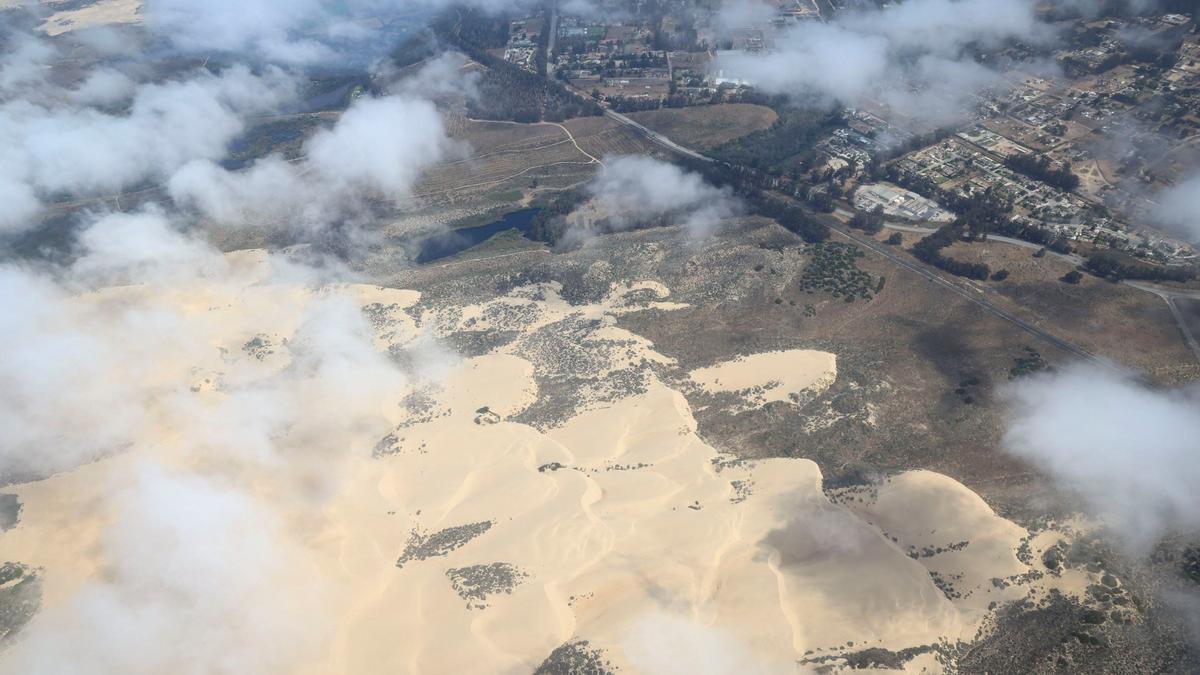 Wind-sculpted sand blown inland from the Oceano Dunes extends toward Highway 1. The Northern Chumash Tribal Council organized an aerial tour of lands bordering the Chumash Heritage National Marine Sanctuary on Sept. 18, 2024. The flight was sponsored by EcoFlight, a nonprofit dedicated to appreciation of the environment.