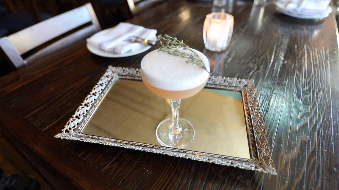 This La Cosecha specialty drink named “You Know Who I Am?” is made with Haku vodka, cranberry, cardamom, lemon and orgeat, infused with with egg white and a sprig of thyme.