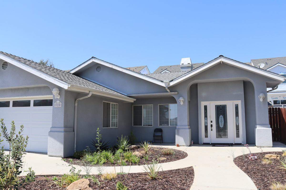 Frames of unfinished homes from the 10850 El Camino Real project can be seen behind Paula Ramsum’s home at the neighboring 930 La Costa Court. She sued the developers for causing her home to flood.