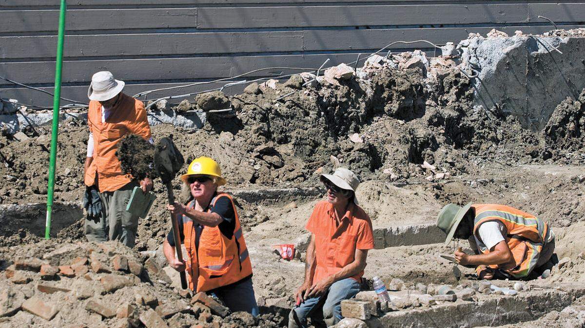 Archaeologists with Applied EarthWorks — from left, Neil Rhodes, Marc Linder, Keith Warren and Phil Clarkson — excavate an area on Monterey Street as part of construction of Copeland Properties' Chinatown project.