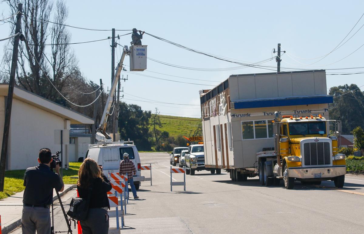 A truck hauls a portion of Arroyo Grande High School’s new music building on Thursday. The structures were big enough that utility lines had to be lifted to make room.