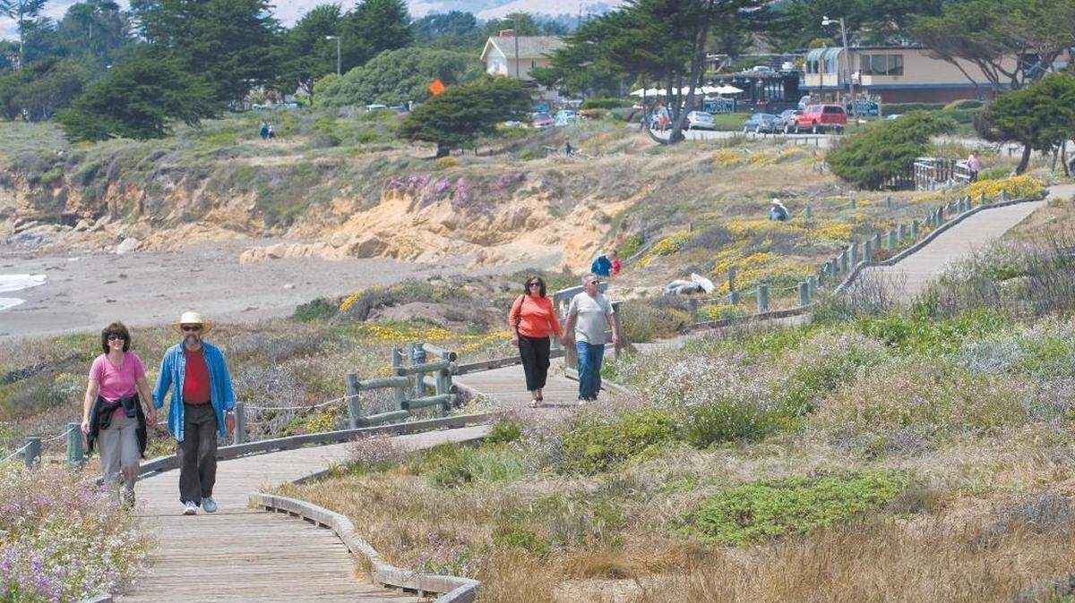 People stroll along the oceanfront Moonstone Beach Boardwalk in Cambria in 2017.