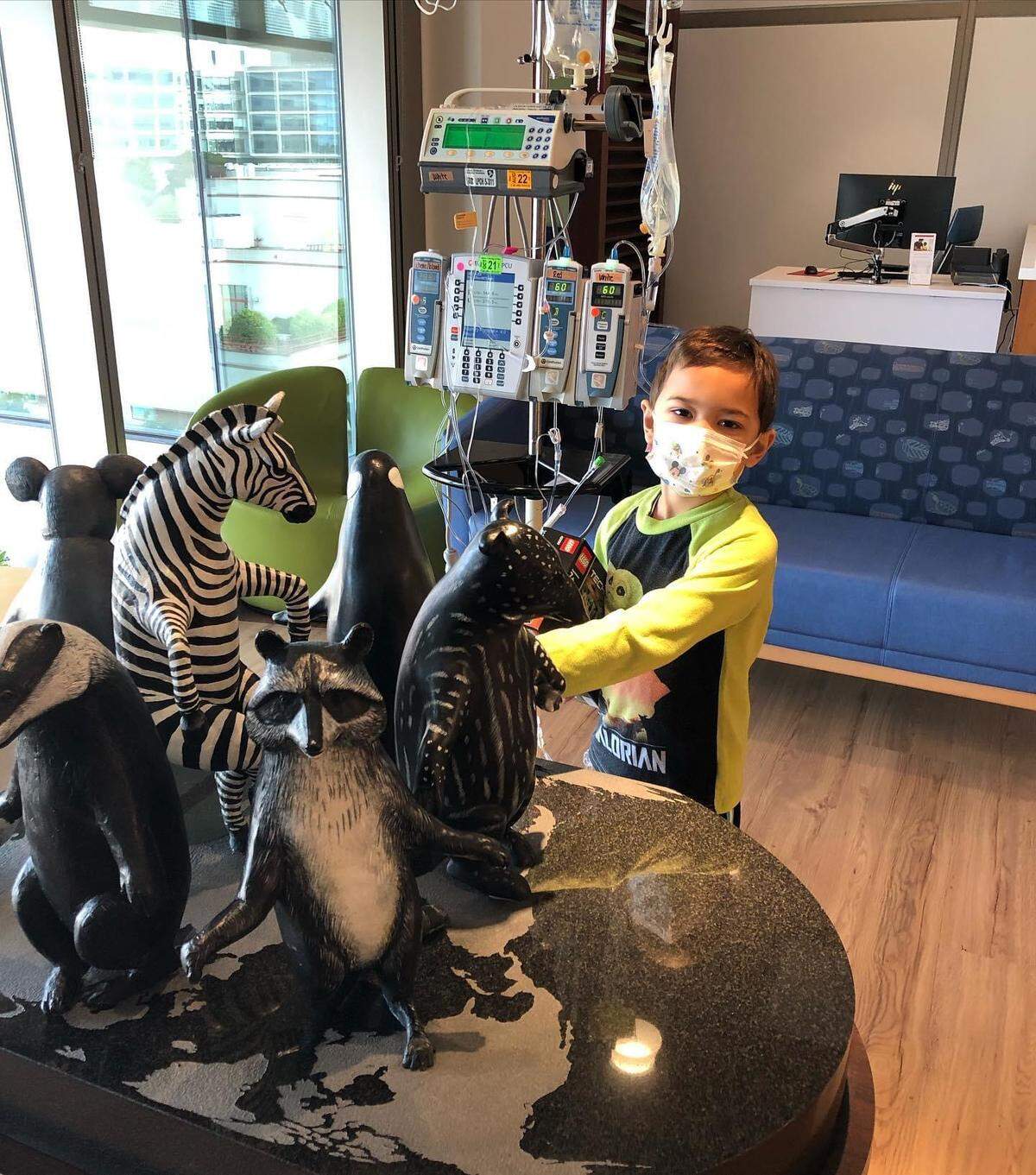 Mason Watson, 6, of Templeton is surrounded by toys and medical equipment as he takes treatments for leukemia.
