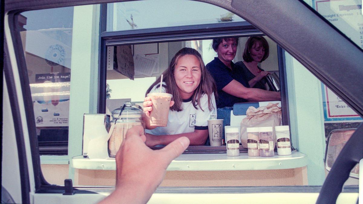 Handoff: Sasha Boehling serves up an iced mocha at the Java Connection drive-through espresso bar in Madonna Plaza, Aug. 13, 1998. The business, which opened earlier this month, found a loophole in San Luis Obispo’s ban on drive-throughs.