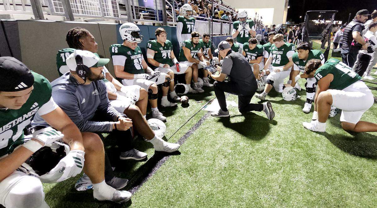 Somber Mustang players listen to their coach in the fourth quarter. Cal Poly fell to Montana State 34-17 in a college football game at Mustang Memorial Field on Oct. 25, 2025.