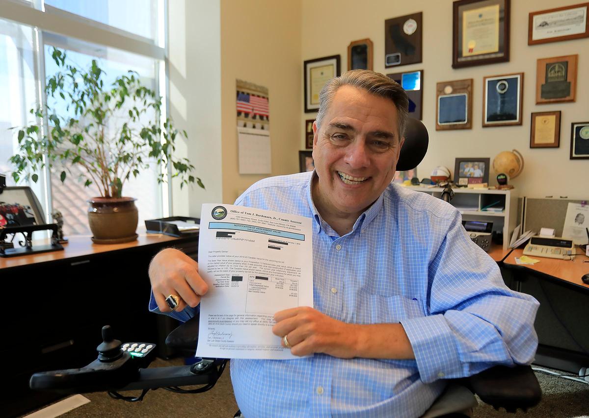 SLO County Assessor Tom Bordonaro Jr. holds a notification of assessment value. Property tax bills arriving in the fall are based on this form.