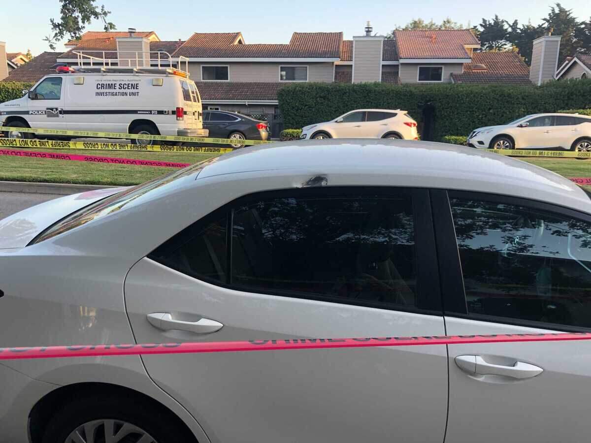 Police tape marks a car that was hit in Monday’s shooting in San Luis Obispo. Two officers were shot, and the suspect is dead.