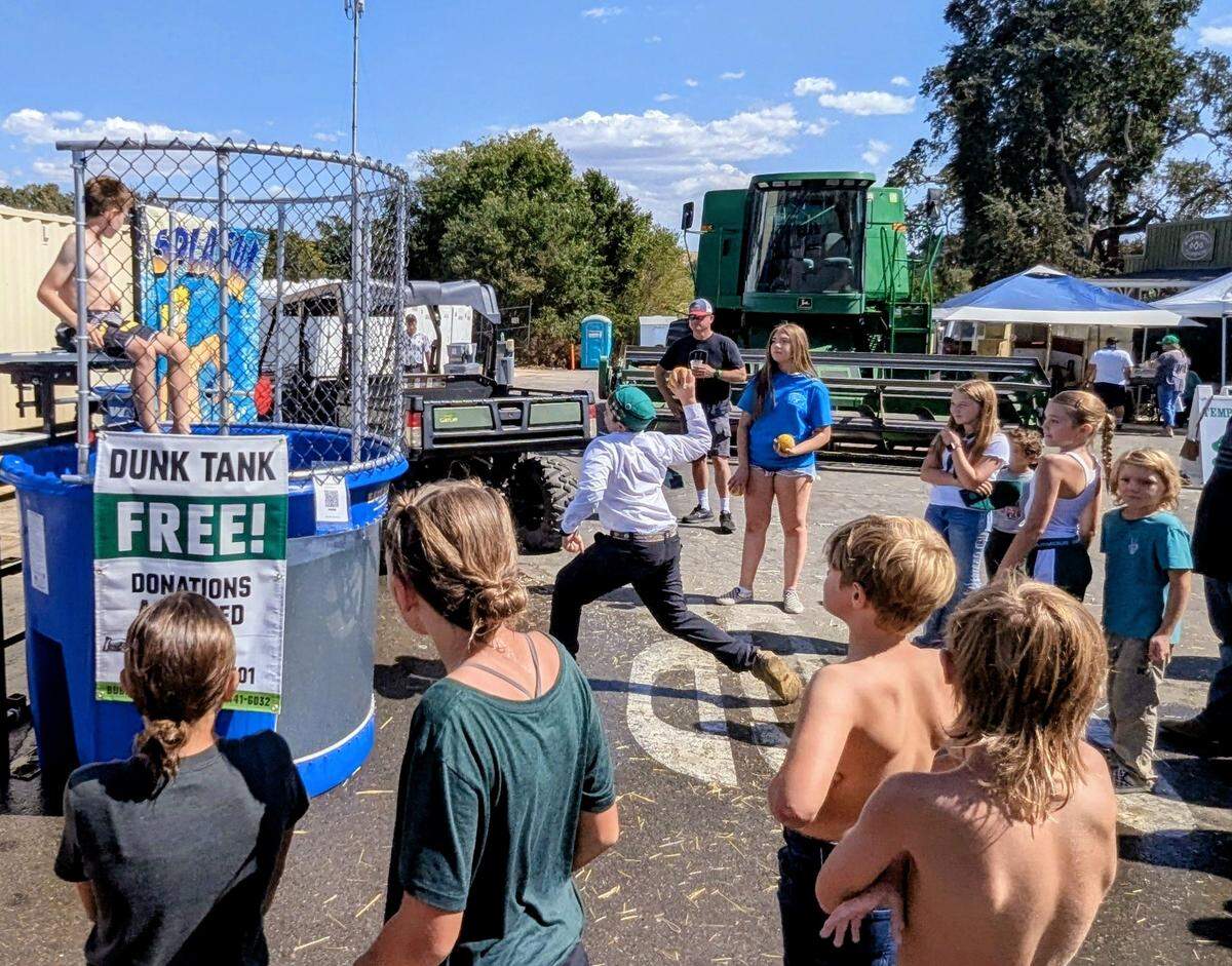 Participants gather near a dunk tank during the Grain Revival fundraiser in Templeton.