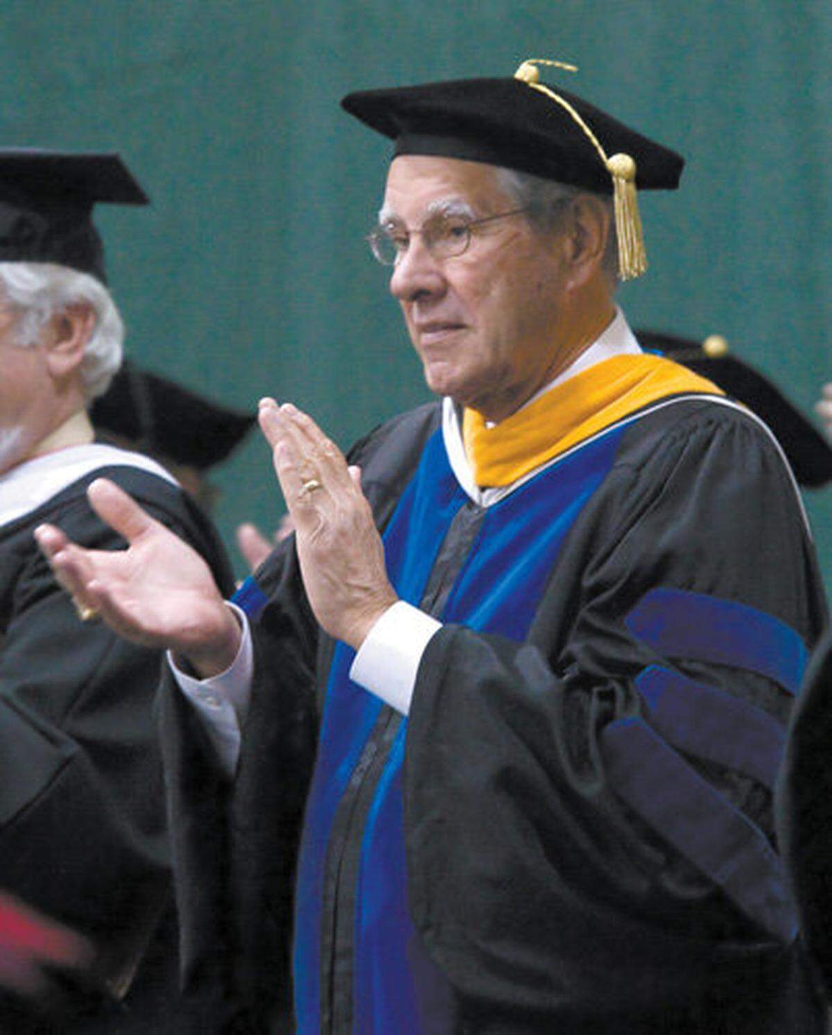 President Warren Baker applauds graduates at Cal Poly’s commencement at Mott Gym on Dec. 12, 2009.