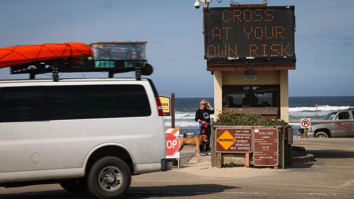 Sign at the Pier Ave. entrance warns “Cross at Your Own Risk.” High flow from Arroyo Grande Creek and high tides sweeping the beach have limited access to the Oceano Dunes to day use from 7 am to 2 pm.