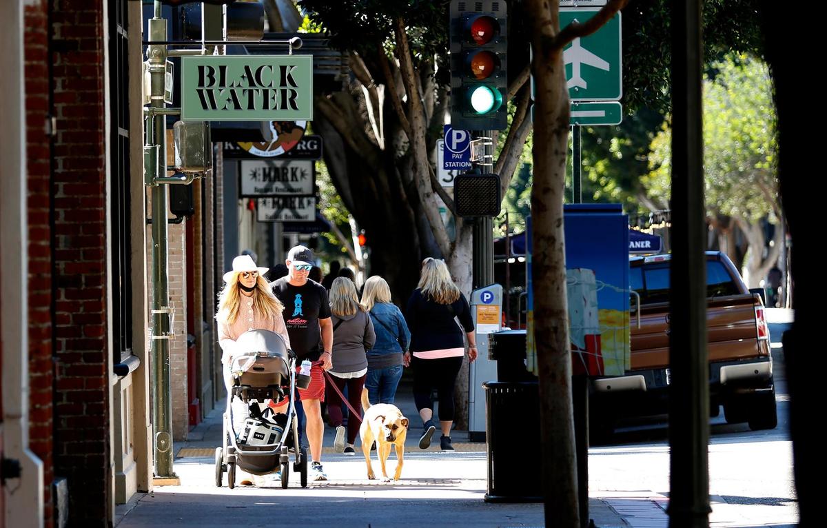 Some people wore masks and others did not while walking on Higuera Street in downtown San Luis Obispo on Wednesday, Feb. 16, 2022, the first day the indoor mandate was lifted for vaccinated people.