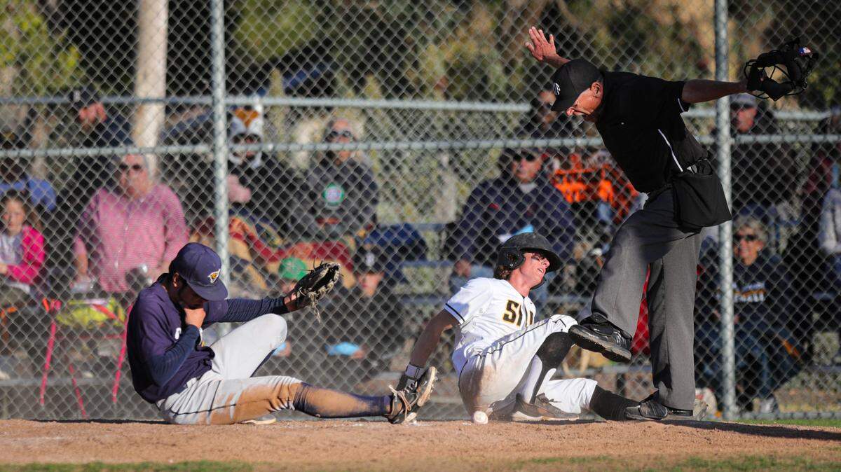 The umpire calls Bo Victor safe at home after he got tangled with pitcher Kaden Tynes and scored on the wild pitch in San Luis Obispo’s 3-1 win over Arroyo Grande on May 12, 2022. Negotiations to increase umpire pay for the 2023 Central Coast high school baseball season broke down, and schools are now looking to use out-of-area umps.