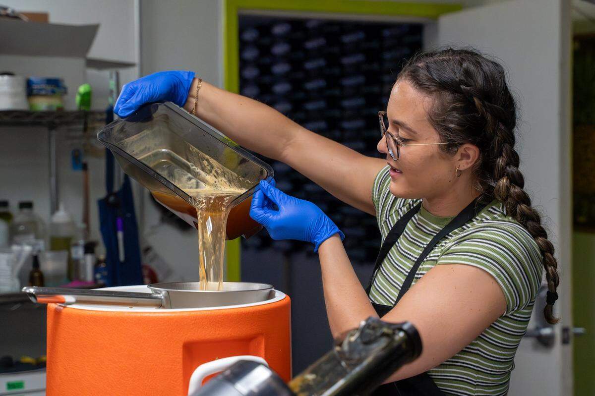 SLO Pressed owner Briana Medvecki pours fresh-pressed apple juice in the kitchen at CaliPaso in San Luis Obispo on Thursday, May 14, 2026. Medvecki started pressing juice in 2025 as a way to treat acne and other skin irritations.