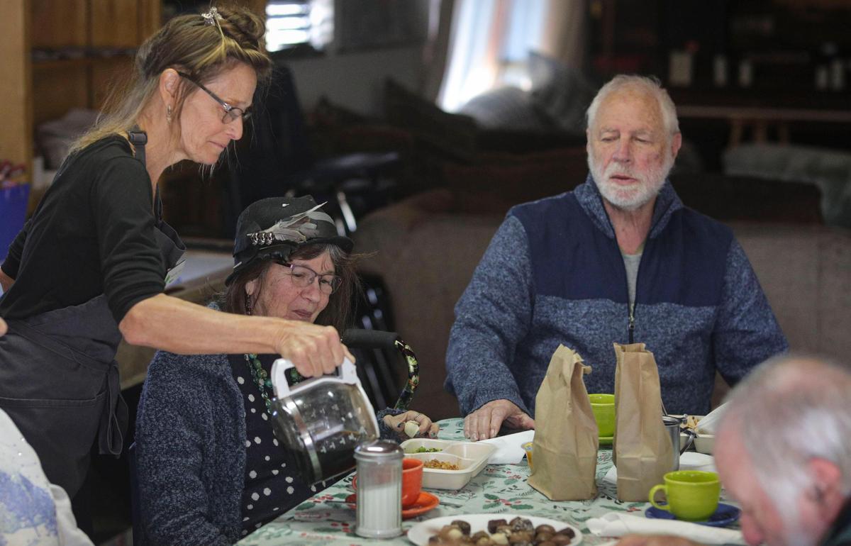 Site hostess Roberta Garcia pours coffee for Chris Anne and Jim at Meals that Connect lunch in Cambria on Dec. 11, 2024.
