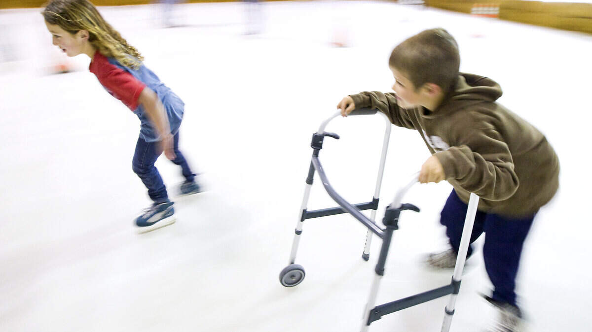 Using a repurposed walker for stability, Casey Jones, 8, chases Andie Elmerick, 7, during an afternoon of skating March 7, 2013, at the Blades On Ice skating rink in Atascadero.