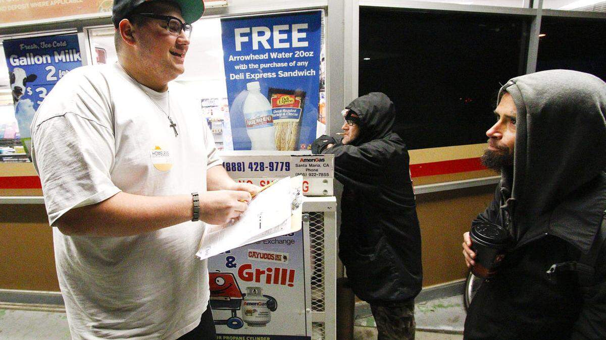 Tony Gagnina, left, talks to two men who gave their names as "Tim" and "T" at a Circle K in Atascadero on Monday, Jan. 26, 2015, during a biennial countywide survey.