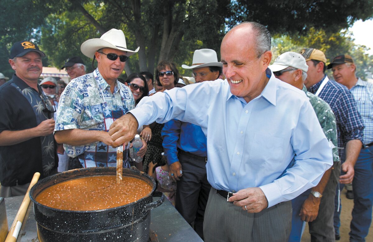 Rudy Giuliani stirs a pot of beans as Dennis Cassidy (in cowboy hat) looks on during a campaign stop in Santa Margarita in June 2007.