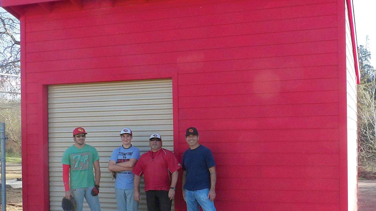 Coast Union baseball players (who painted the shed) Tommy Moreno, left, and Nic Robertson stand beside the new storage facility with head coach Brian Machado and assistant coach and Lions President Andy Zinn.