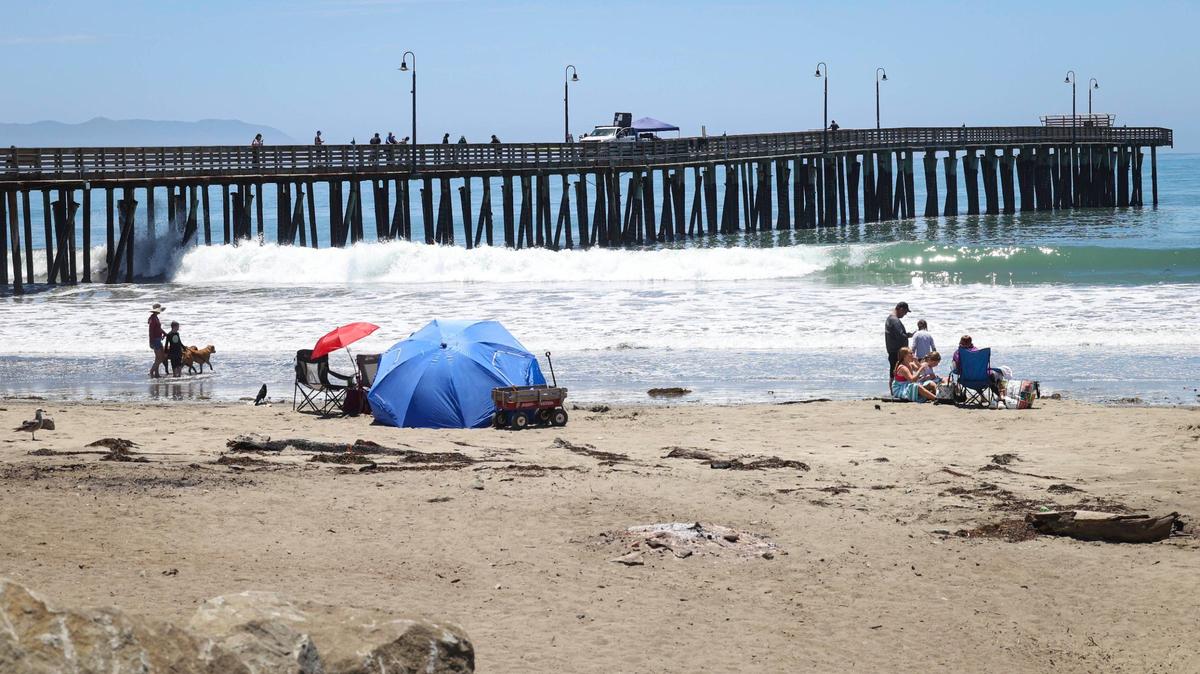 The end of Cayucos Pier was damaged in a Feb. 20, 2024 storm when pilings were washed away. Beach goers enjoy the sun as the damage is being inspected. This view is from June 25, 2024.