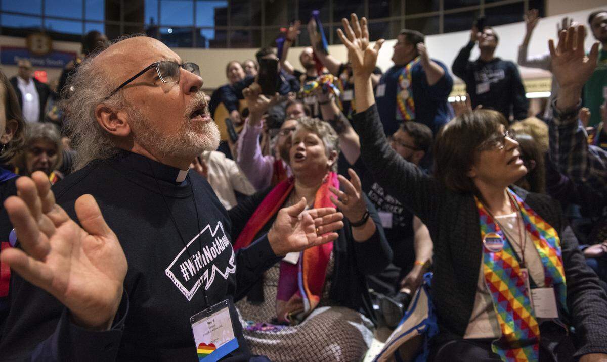 The Rev. K Karen, left, of St. Paul & St. Andrew United Methodist Church in New York joins other protesters in song and prayer outside the United Methodist Church’s special session of the general conference in St. Louis, Tuesday, Feb. 26, 2019. America’s second-largest Protestant denomination faces a likely fracture as delegates at the crucial meeting voted to strengthen bans on same-sex marriage and ordination of LGBT clergy.