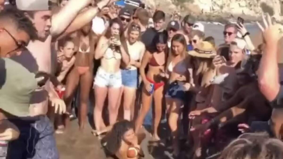 A screenshot from a video shows students partying at Pirate’s Cove Beach in September. Cal Poly officials say more recent gatherings have contributed to a surge in student cases .