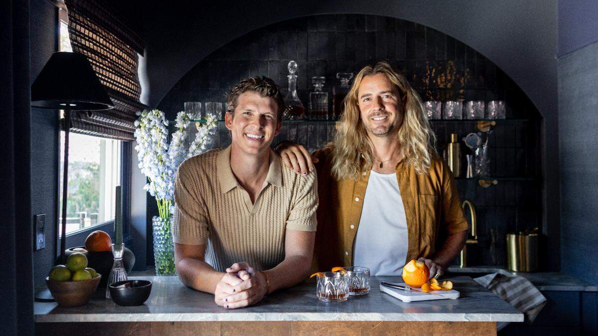 Tommy Rouse, left, and husband Joshua Smith pose for a picture on the set of HGTV show “Revealed.”