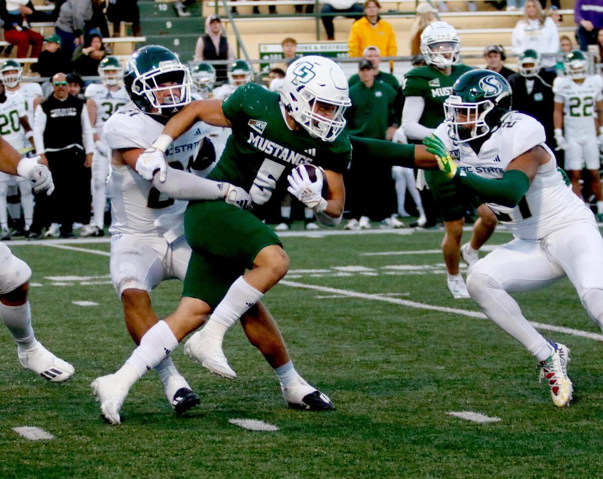 Cal Poly running back Aidan Ramos is tackled by Hornet defenders Will Leota, left, and Gavin Davis-Smith. Cal Poly beat Sacramento State 26-23 in a college football game at Mustang Memorial Field on Saturday. 