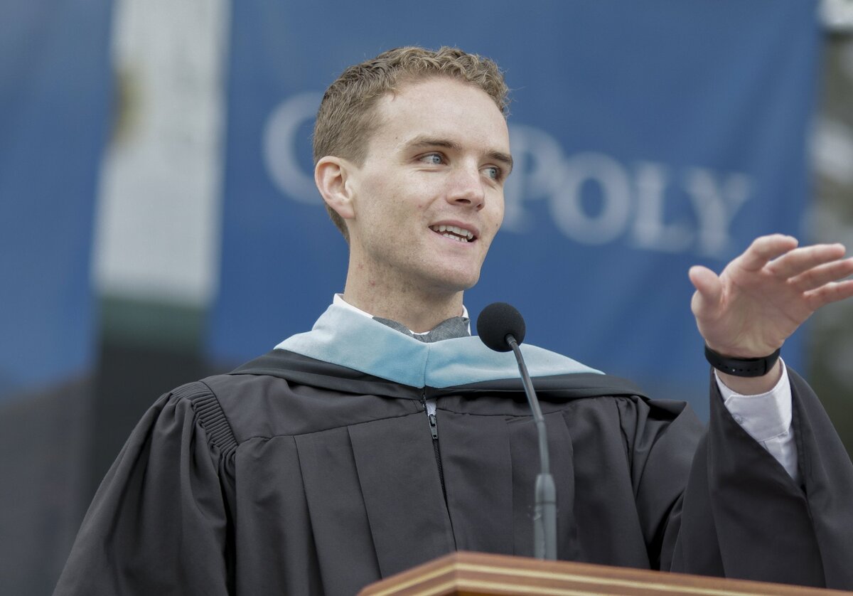 Keynote speaker Wyatt Oroke, a Cal Poly alum and humanities teacher in Baltimore, gestures toward the crowd during his address in the Cal Poly graduation commencement ceremony for College of Agriculture, Food and Environmental Sciences and College of Science and Mathematics on Saturday, June 16, 2018.