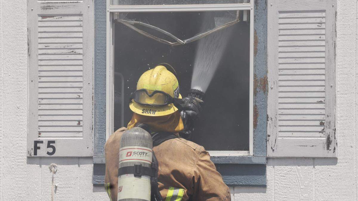 A firefighter sprays water into a mobile home at the site of a structure fire in Santa Margarita on Friday, May 13, 2022. At least five mobile homes were destroyed in the blaze at the Santa Margarita Mobile Home Park.