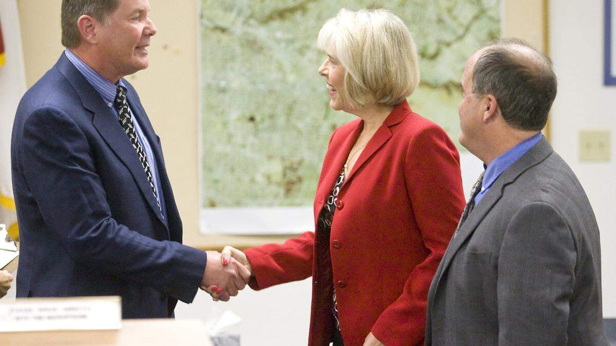 Jim Hill, Arroyo Grande's newly elected mayor, and Barbara Harmon, a new City Council member, shake hands while returning incumbent Tim Brown waits his turn after all were sworn in at the Arroyo Grande City Council meeting on Monday, Dec. 1.