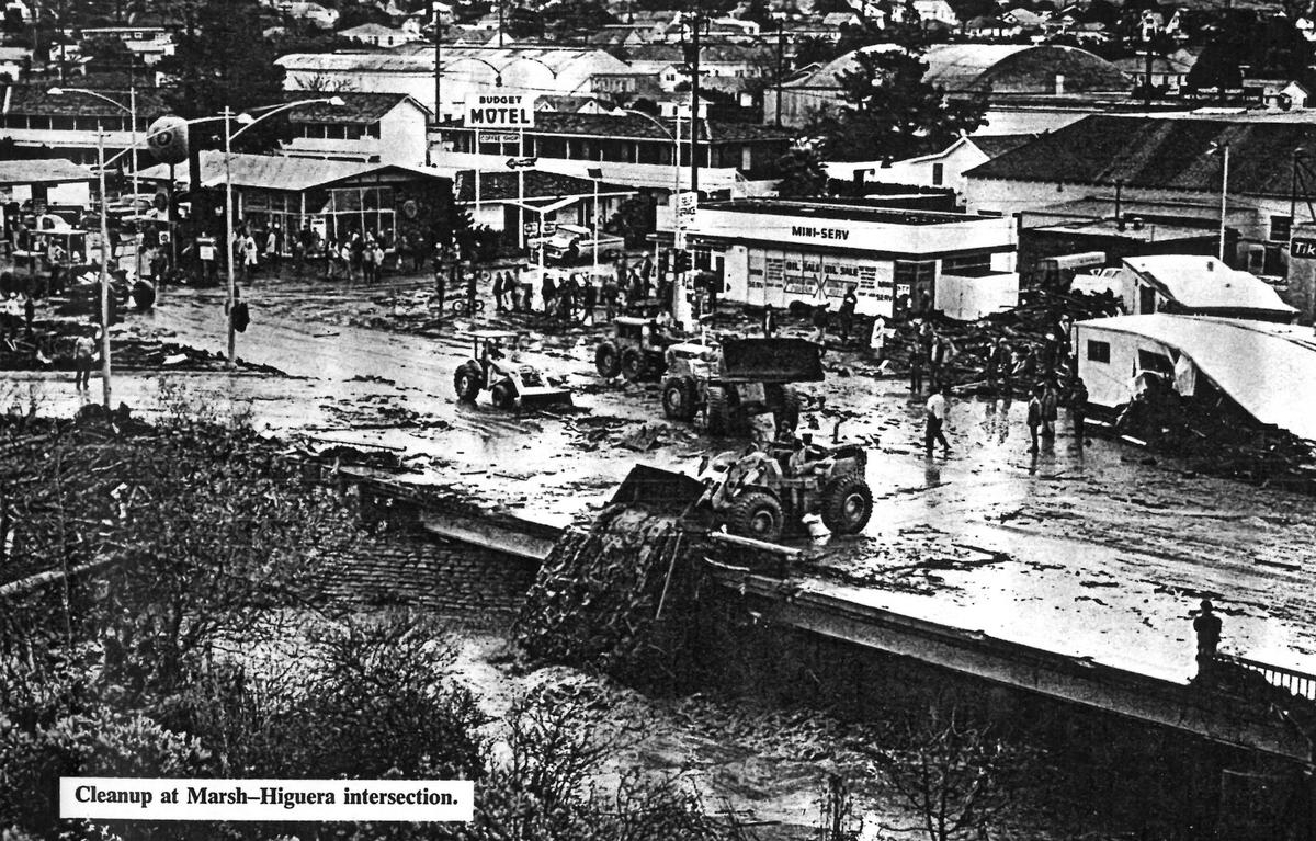 Marsh and Higuera is covered with mud and mobile homes as buckets of mud are dumped into San Luis Creek after the January 1973 flood.