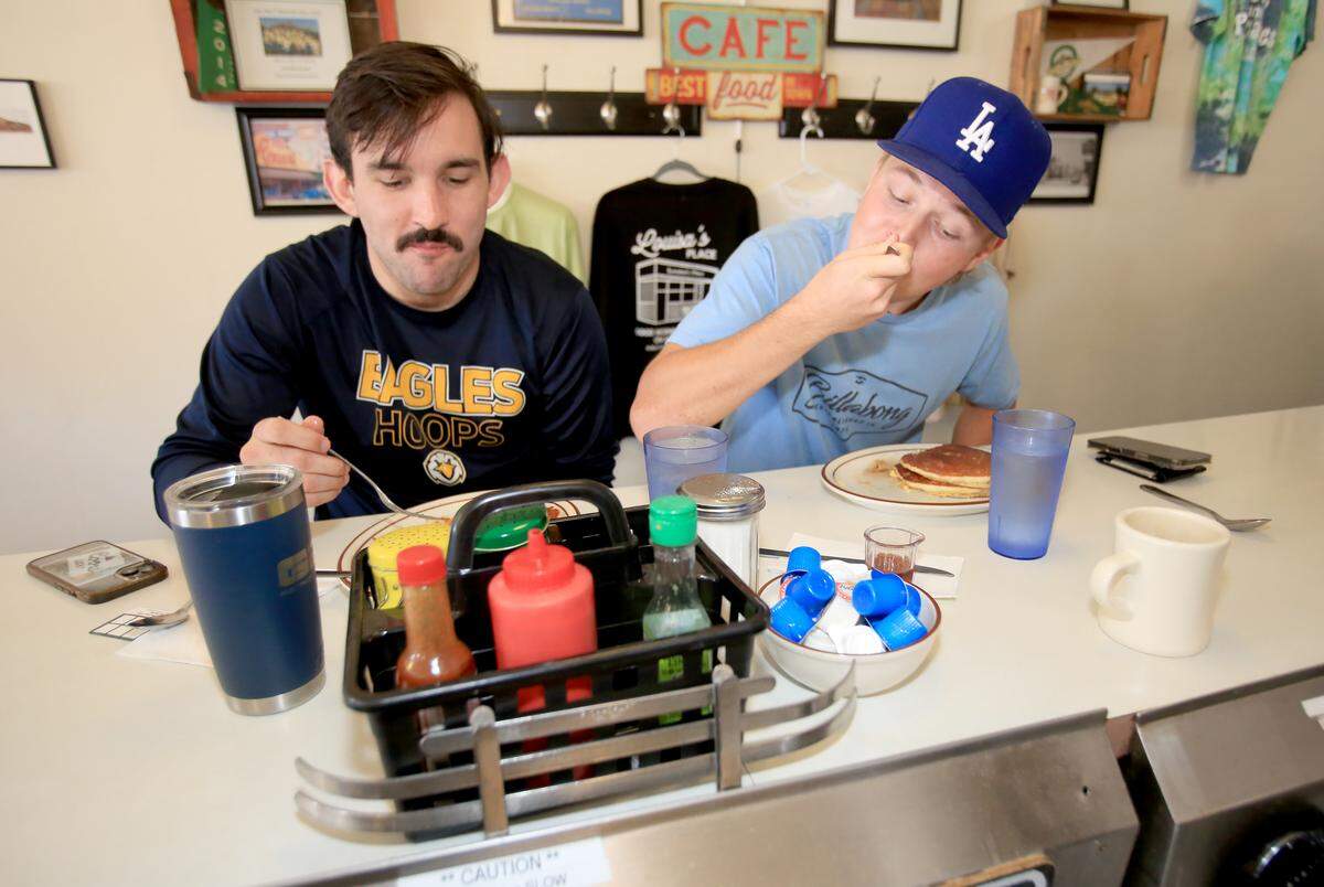 Cal Poly student Tyson Schmidt, left, and Cuesta College student, Carson Weller dig into their breakfasts at Louisa’s Place. They’re both from Arroyo Grande and meet at the diner every Thursday.