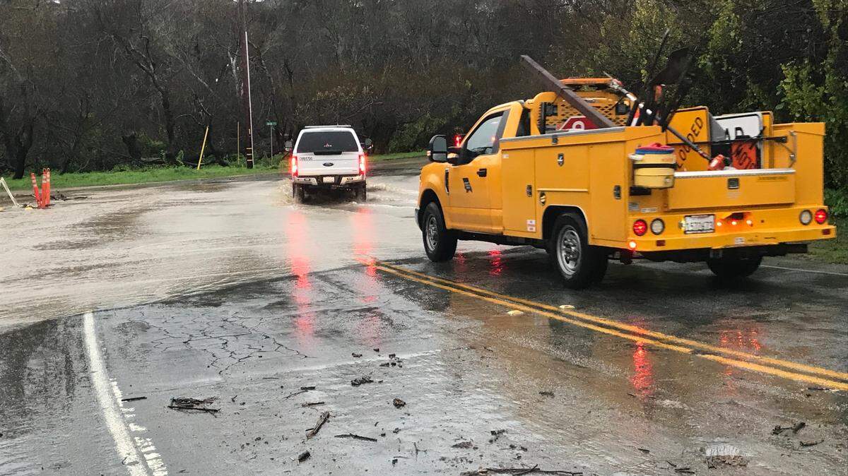 A Cambria Fire Department vehicle and county truck gingerly traverse remaining floodwaters on Windsor Boulevard in Cambria after officials reopened the access road to Park Hill on Jan. 9, 2023. Earlier that day, deeper runoff and public-safety concerns had prompted a seven-hour closure of the busy road. If the floodwaters rise again during incoming storms, officials may need to close the boulevard down again.