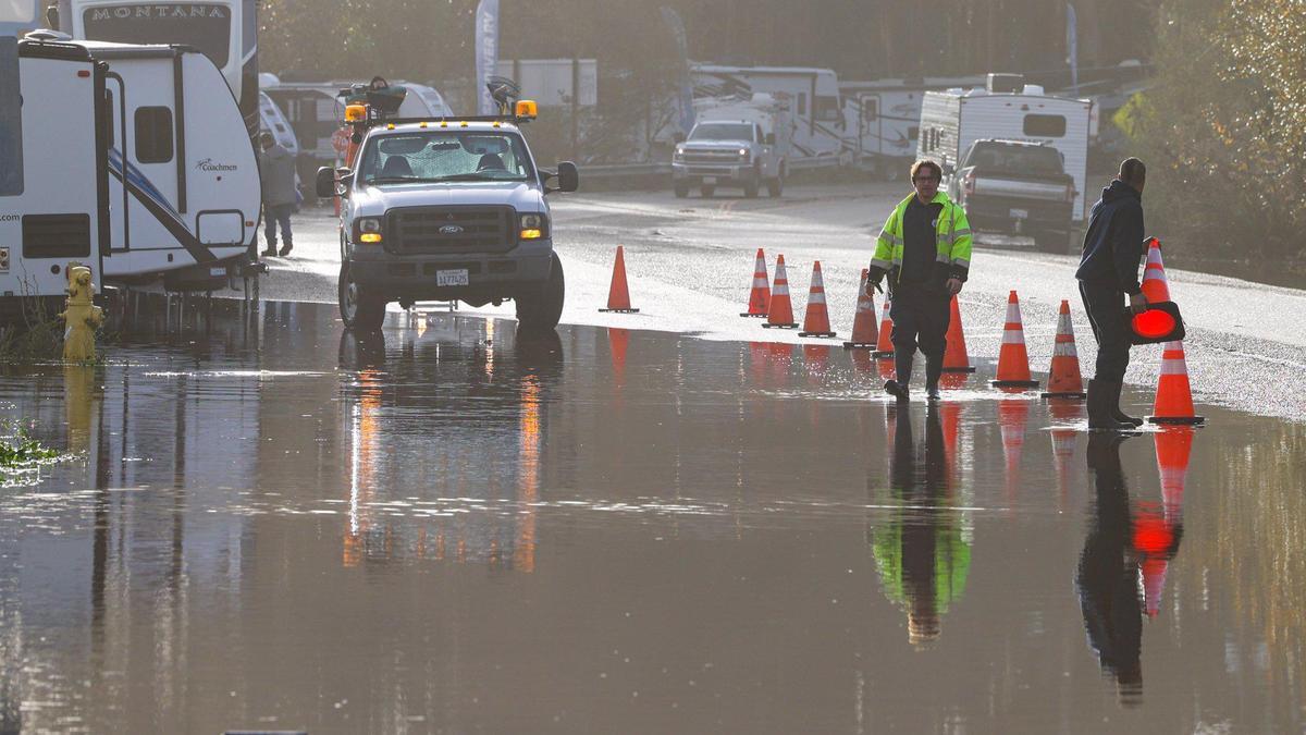 A work crew sets out cones along Highway 1 in Pismo Beach in a flooded spot. A break in the storm track on the morning of Jan. 10, 2023, as series of atmospheric river storms hit the coast.