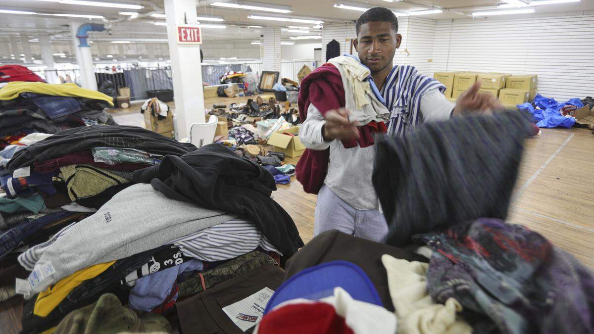 Thrifty Beaches co-owner Adam Kemp sorts clothing into categories on Sept. 3, 2025.