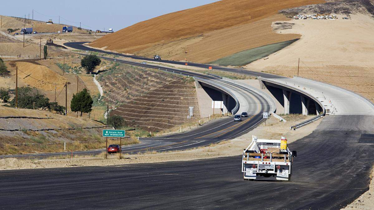 In 2013, a work truck travels along the unopened expanded portion of Highway 46 East, right, near Almond Drive.
