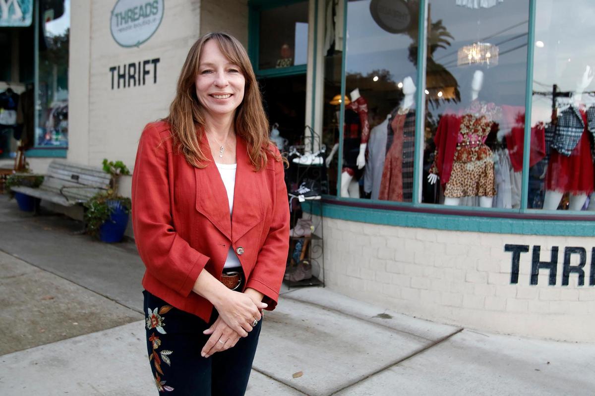 Threads Resale Boutique owner Kim Pelzel poses for a picture in front of her store, which is moving to a new location in February.