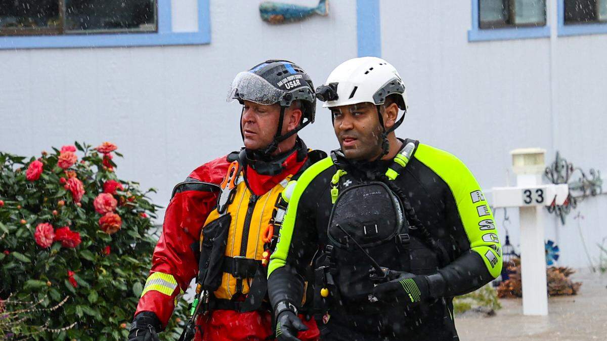 Cambria Fire Chief Justin Vincent, right, with Fire Capt. Michael Burkey, went door-to-door evacuating residents as Santa Rosa Creek flooded the Oak Terrace Mobile Home Park in March 2023. Vincent, who was terminated in October 2023 and replaced as chief by Burkey, sued the Cambria Community Services District over the firing and won a $200,000 settlement in December 2025.