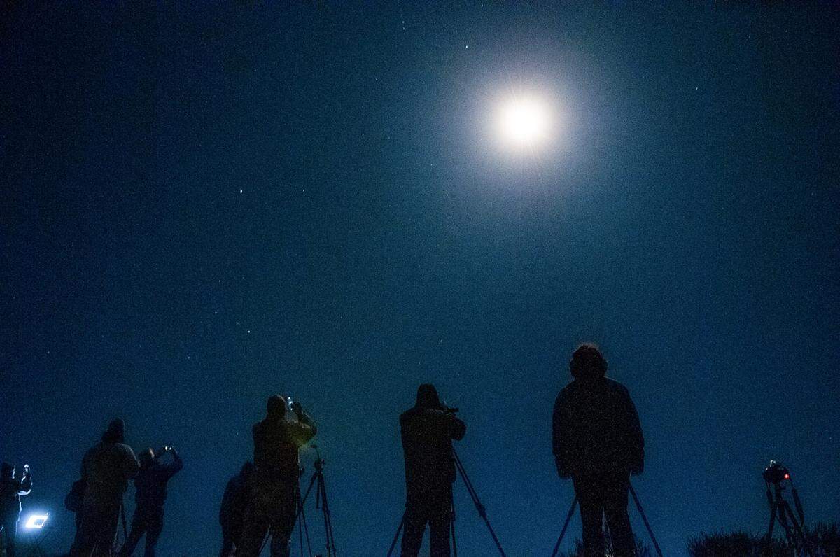 Photographers watch an Atlas V rocket flies from Vandenberg Space Force Base near Lompoc on Thursday, Nov. 10, 2022.