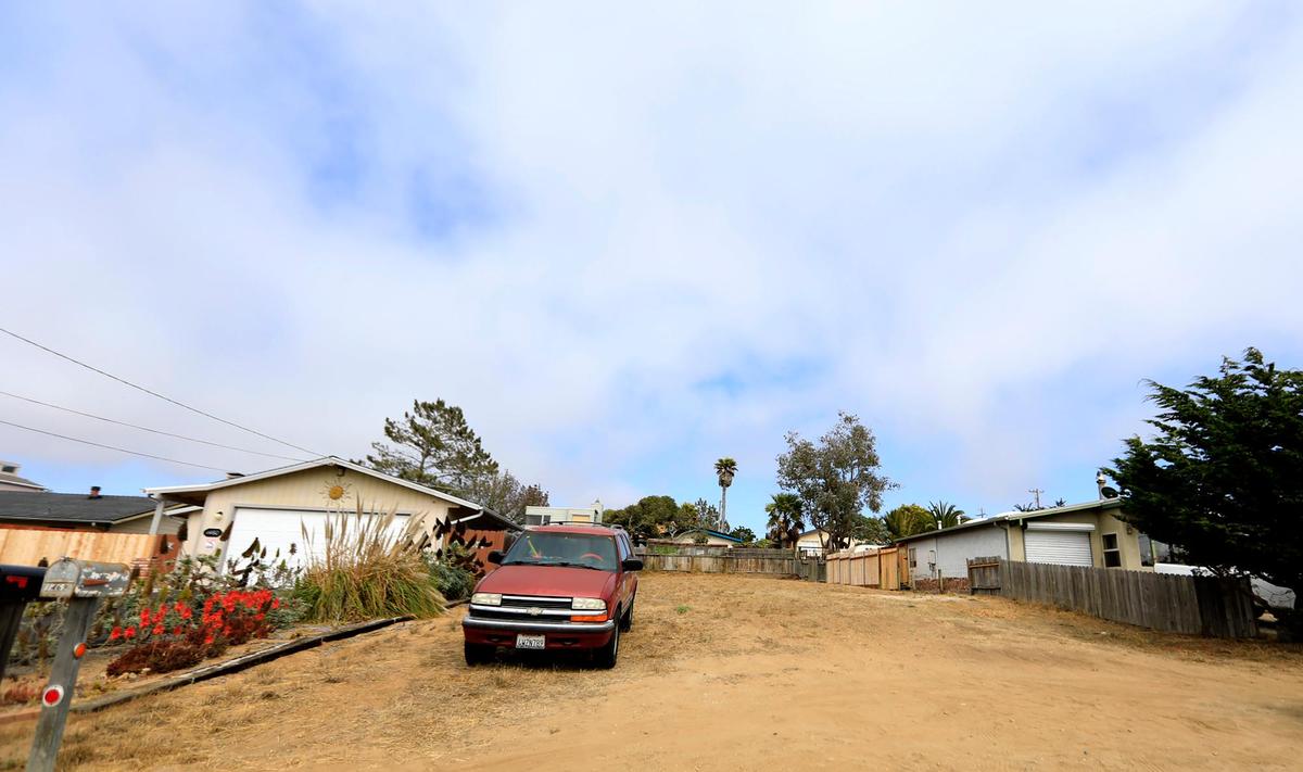A car parks on an empty lot at the 1400 block of 12th Street in Los Osos. Empty lots like this are scattered all over town with property owners unable to build amid a long-running moratorium that may finally be coming to an end.