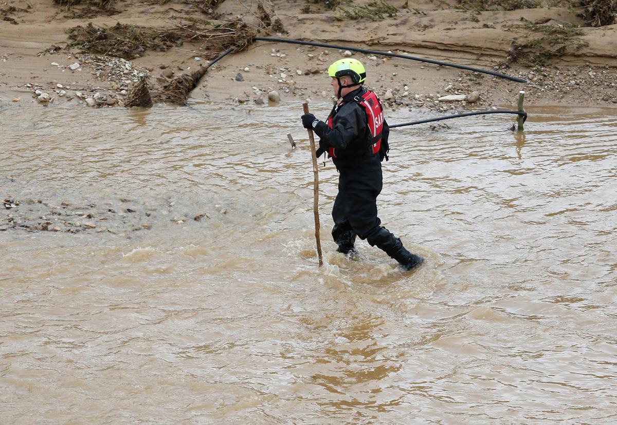 Searchers check through floodwaters for any sign of 5-year-old Kyle Doan on Wednesday, Jan. 11, 2023, two days after he disappeared in swollen San Marcos Creek near San Miguel.