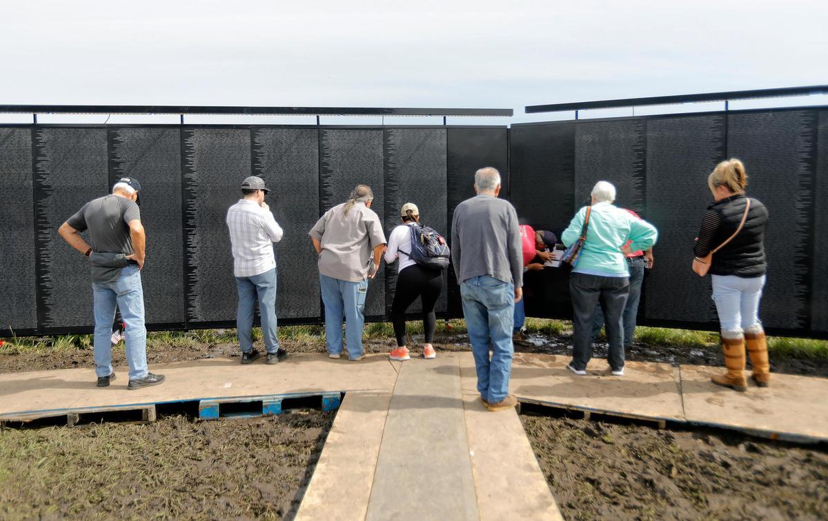 Community members visit The Wall that Heals, a touring replica of the Vietnam Veterans Memorial in Washington, D.C., in San Luis Obispo on Saturday, March 18, 2023.