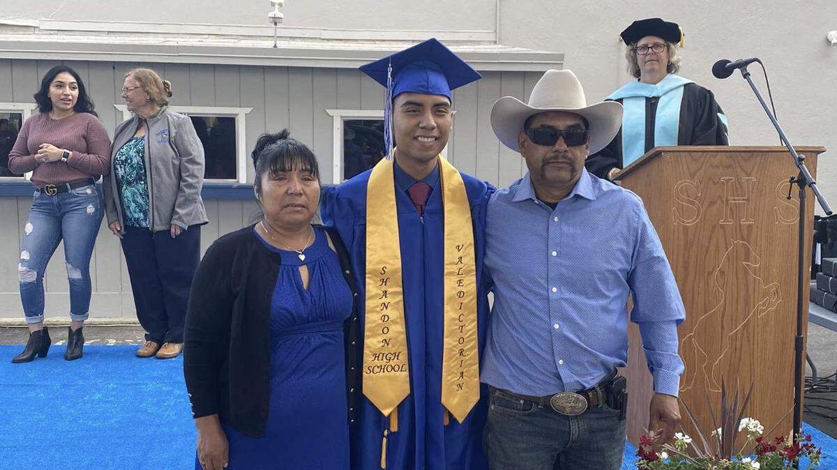 Shandon High School valedictorian Isaac Lopez poses for a photo with his parents at Friday’s graduation.