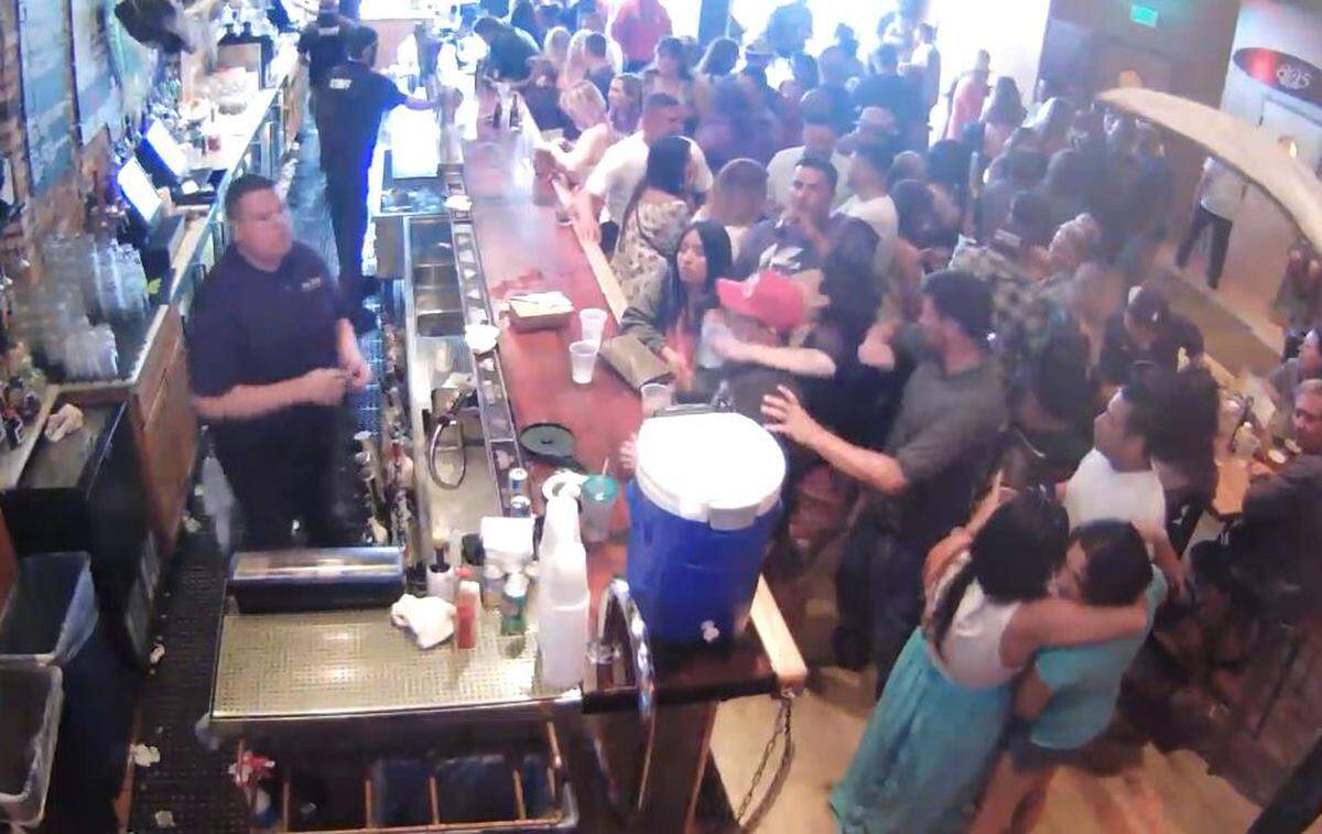 Christopher Olcott, in brown shirt, throws his elbow at the head of Camille Chavez on May 28, 2016, at Mr. Rick’s bar in Avila Beach. Olcott, a San Luis Obispo building inspector, has been placed on paid leave. He pleaded guilty to misdemeanor battery after a felony trial ended in a hung jury last year.