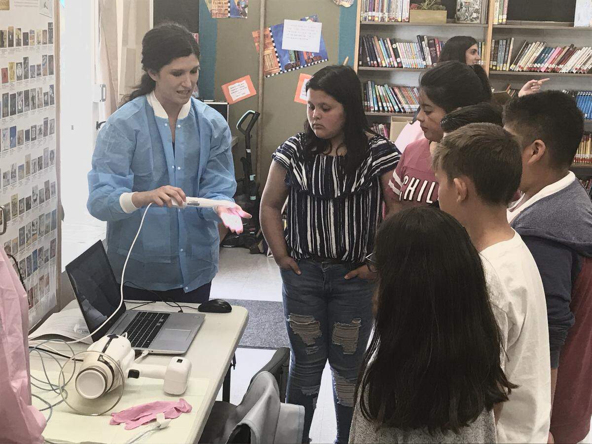 A dental hygienist shows her equipment to students of Grover Beach Elementary School students during a demonstration of the new pop-up clinic.