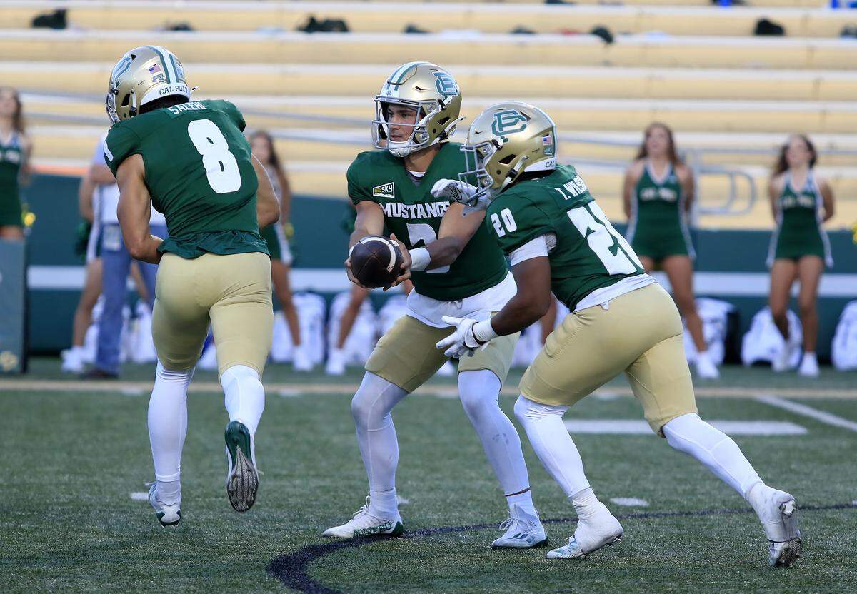 Mustang quarterback Bo Kelly makes a handoff to Trey Wilson. Cal Poly lost to UC Davis 34-27 in a college football game at Mustang Memorial Stadium on Oct. 4, 2025.