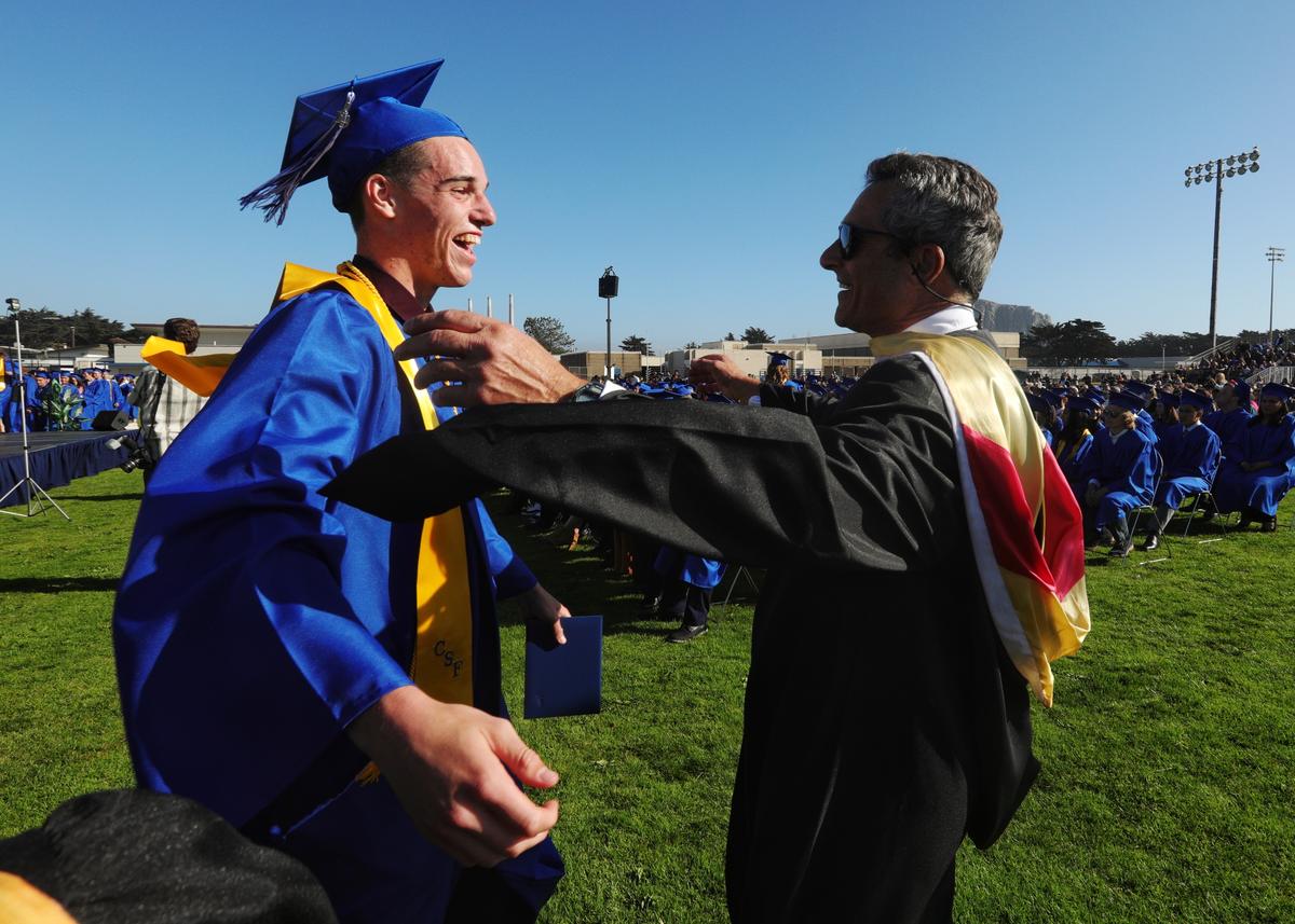 Jacob Furbee gets a hug from English teacher Daniel Freeman as Morro Bay High School celebrated 181 graduates Thursday evening.